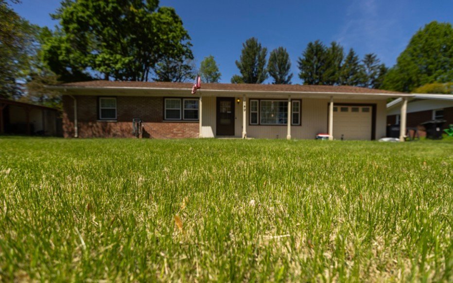 Green front lawn outside a single-story home