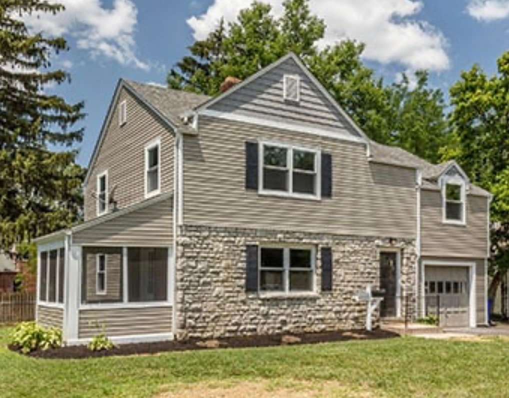 Two-story house with stone siding and a front lawn